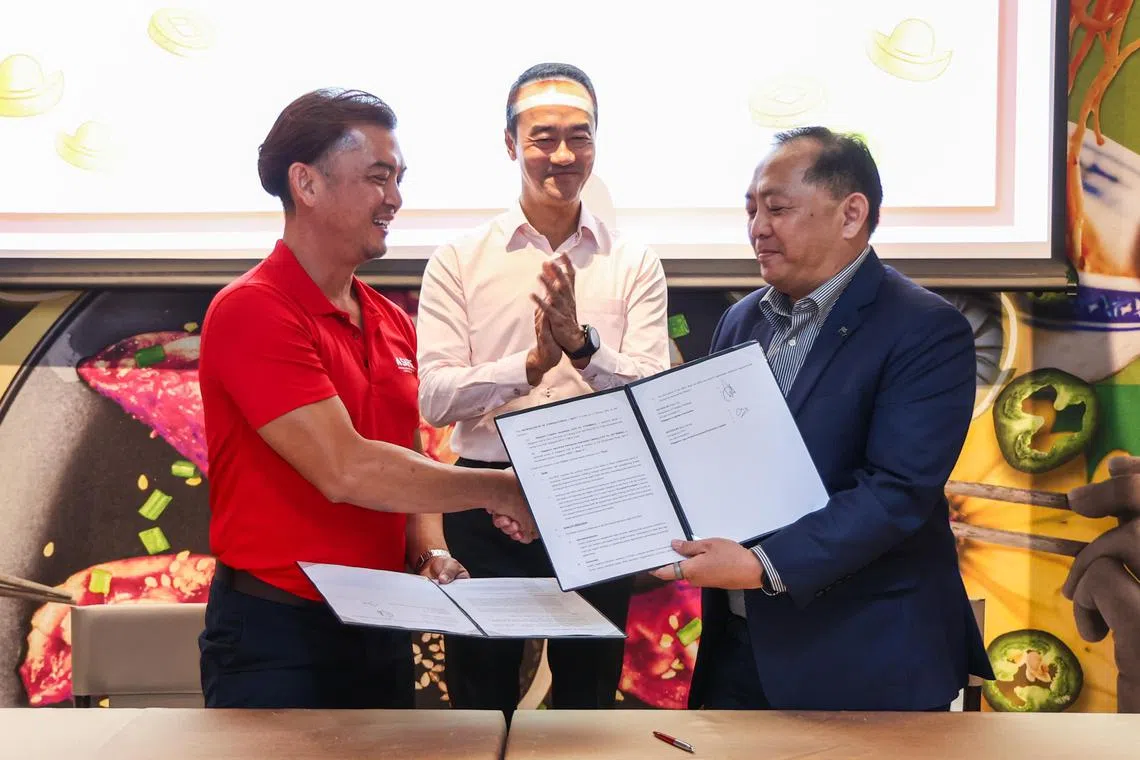 新加坡鲜农总会首席执行官张国健（左）和新加坡物流协会副会长林日聪（右）签署谅解备忘录，双方要合力优化农产品运输成本。永续发展与环境部兼人力部高级政务部长许宝琨医生（中）见证签署仪式。（白艳琳摄）