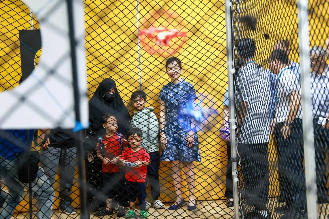 数码发展及新闻部兼教育部政务部长刘洁敏在机器人节开幕式现场，观看小朋友操作无人机。她鼓励家长多带孩子参与这类活动，激发孩子对科学的兴趣，（陈斌勤摄）