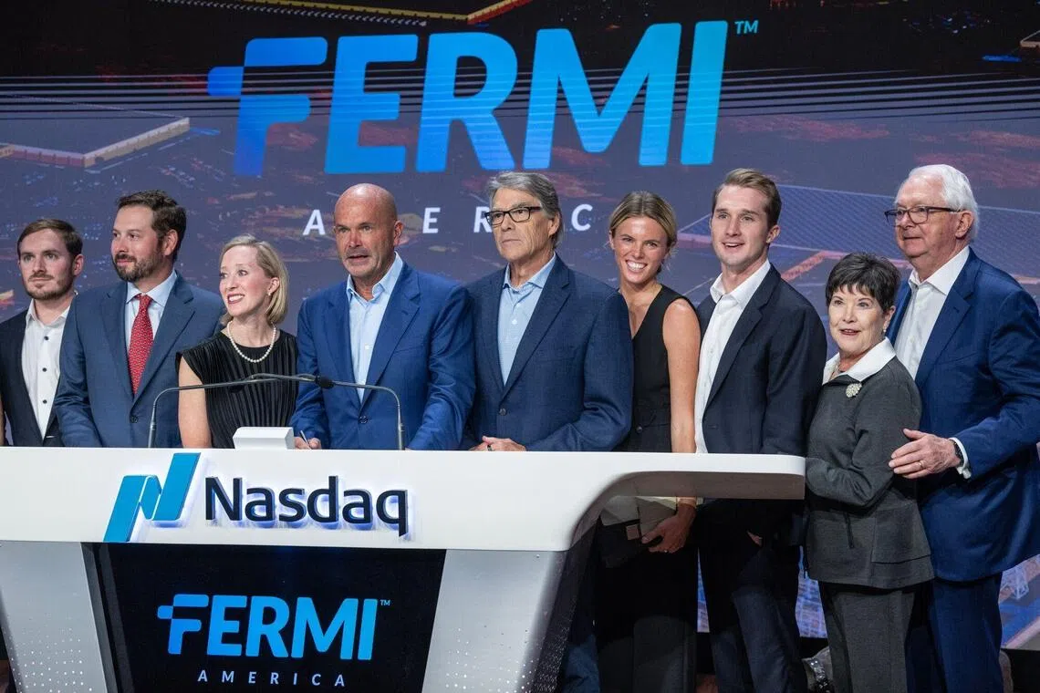 Fermi首席执行官诺伊格鲍尔（左四）和美国能源部前部长佩里（右五）在公司首日挂牌交易时敲响收盘钟。（彭博社）