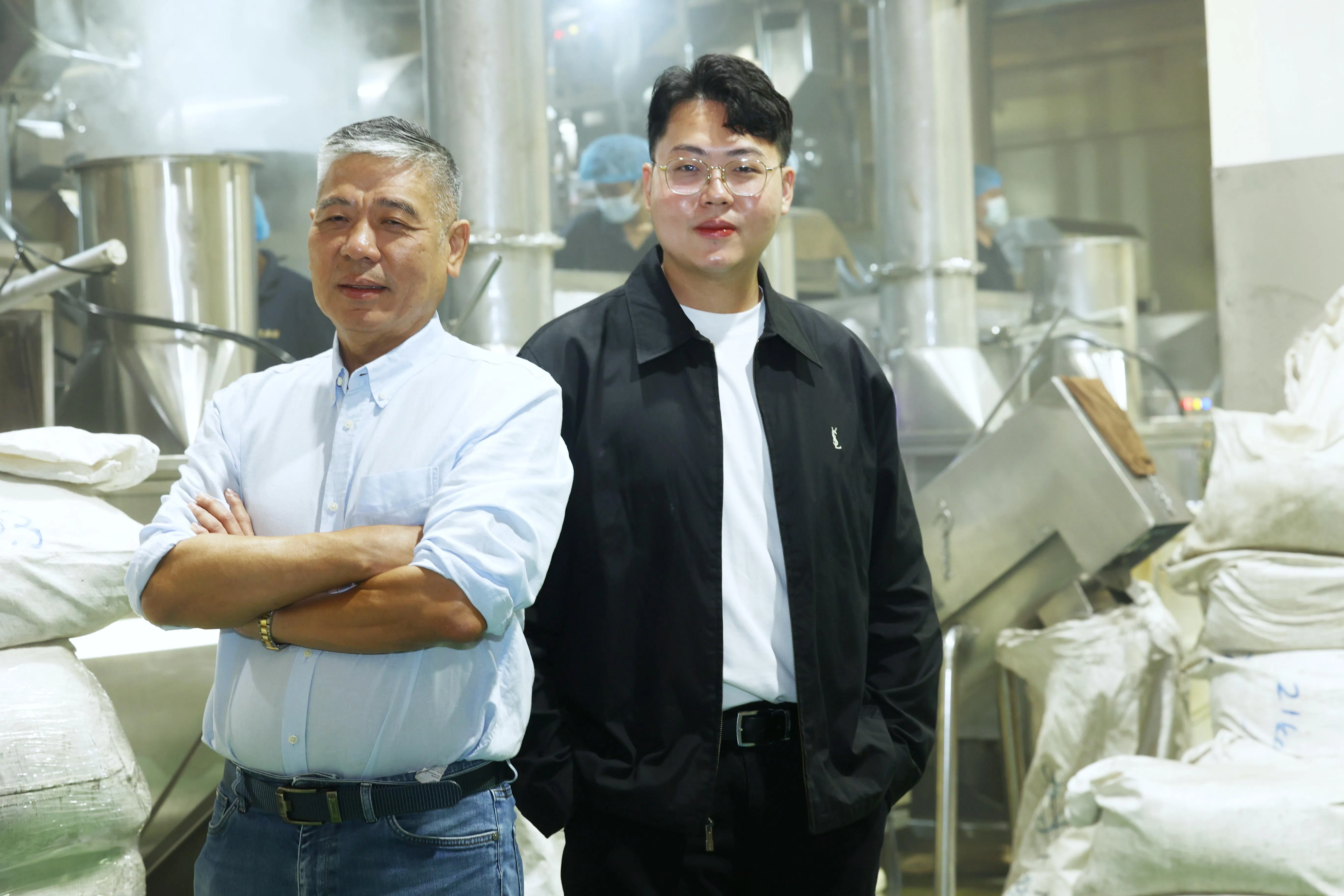 孙利顺（左）不断改良咖啡豆烘焙机器，在确保品质保持一致的同时，减轻对人力的依赖。长子孙昱轩的加入，弥补他在数码以及品牌塑造方面的不足。（郑一鸣摄）