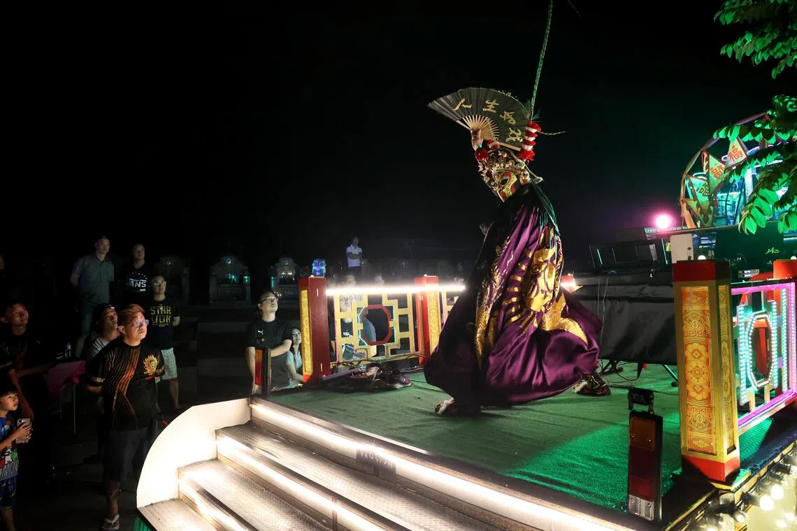 蒋保罗午夜时分在坟场表演变脸。（龙国雄摄）