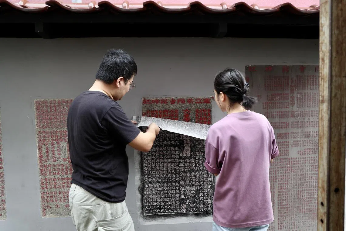 待纸张达到适当干度后，便可取下，拓片即完成。（陈斌勤摄）
