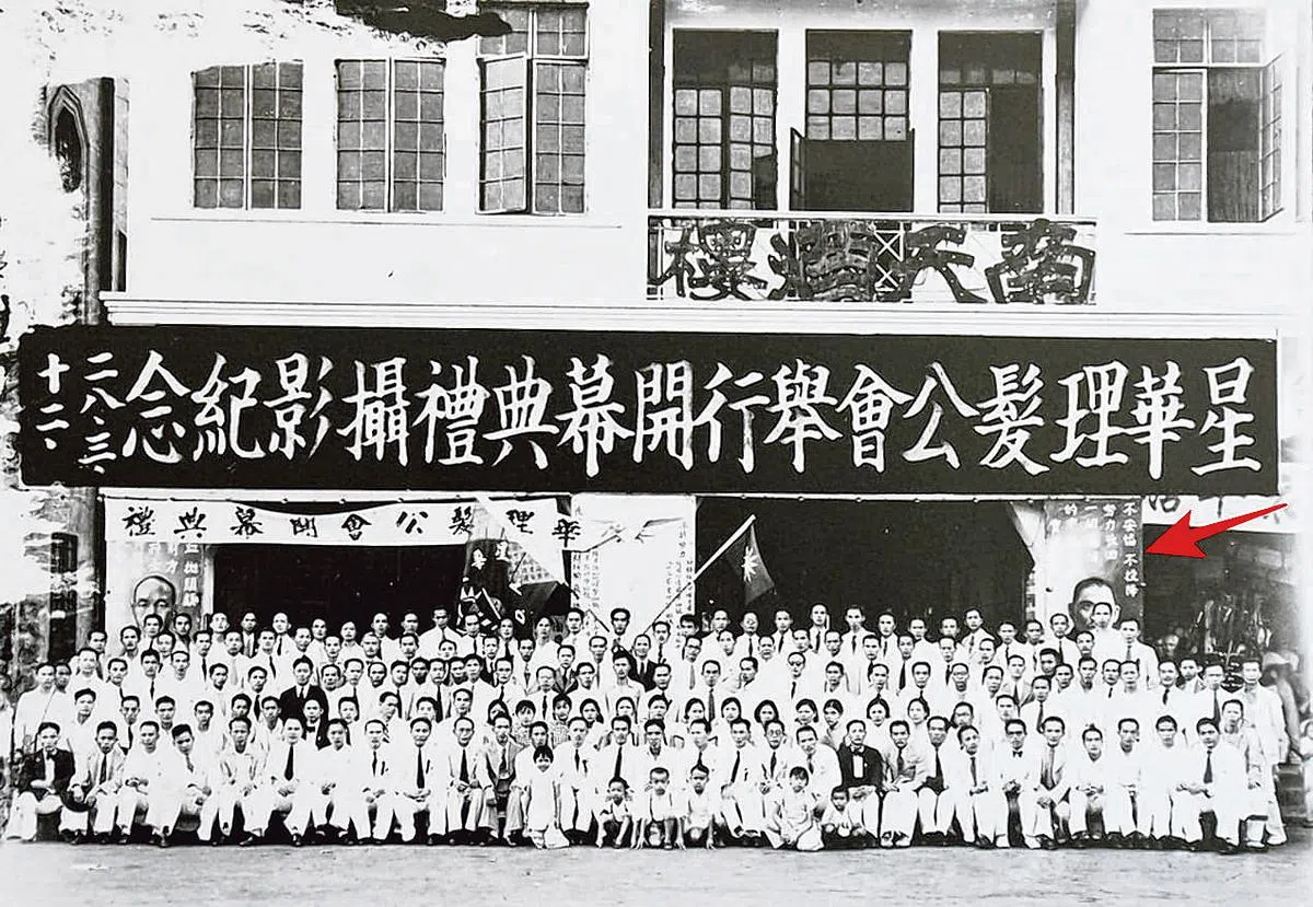 1939年3月12日“星华理发公会开幕典礼摄影纪念”。箭头处的标语为 “不妥协，不投降，努力收回一切沦陷的中华土地，实现民族解放”。