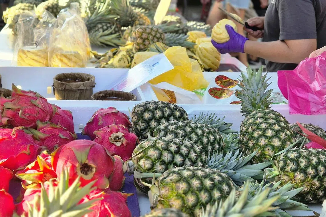 新鲜水果与贴心服务，成为顾客与摊主之间信任与默契的纽带。（陈爱薇摄）