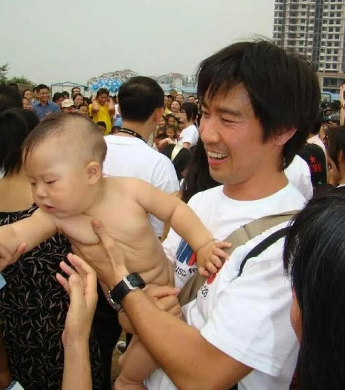 陈之财当年在灾区抱起小宝宝。（受访者提供） 