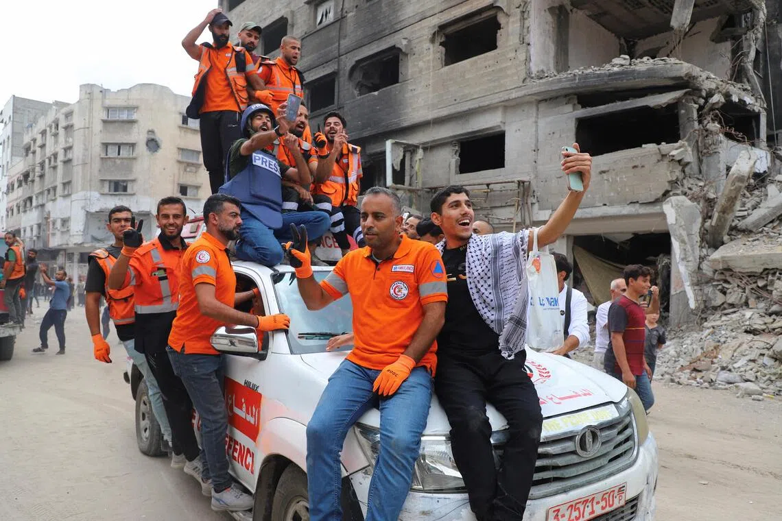 巴勒斯坦救护人员星期四在加沙城街头欢庆以哈达成停火协议。（路透社）