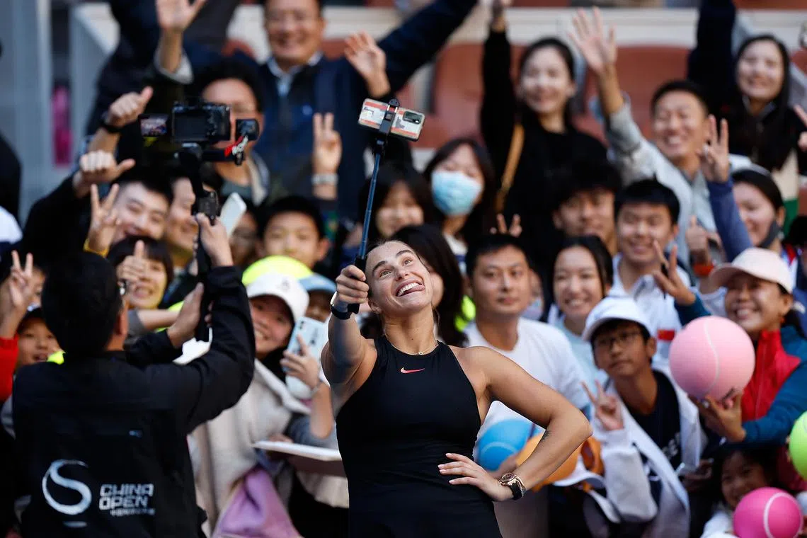 白俄罗斯球员阿丽娜（中下）轻松获胜后与现场观众自拍。（新华社）