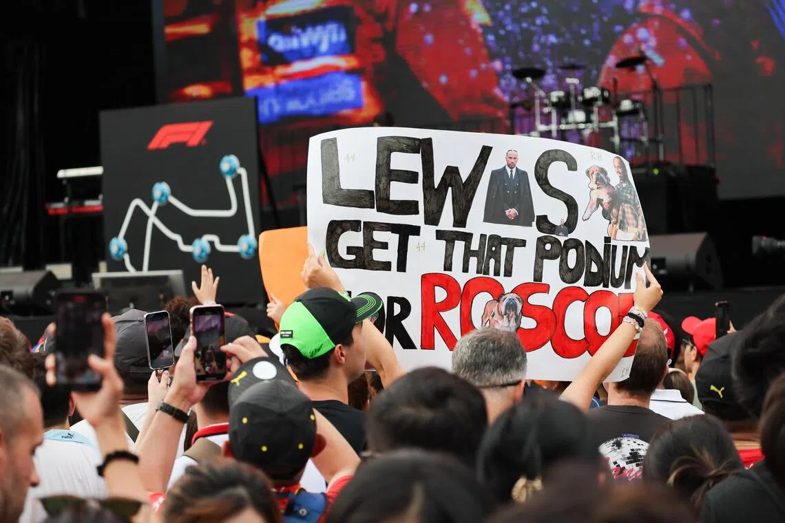 车迷高举写有希望“哈密尔顿能为罗斯科登上领奖台”的应援板。（张俊杰摄）