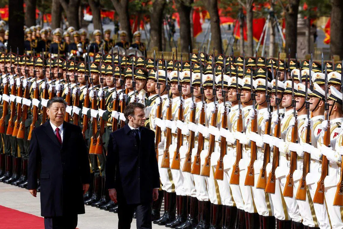 习近平与马克龙在中国人民解放军仪仗队旁走过。（路透社）