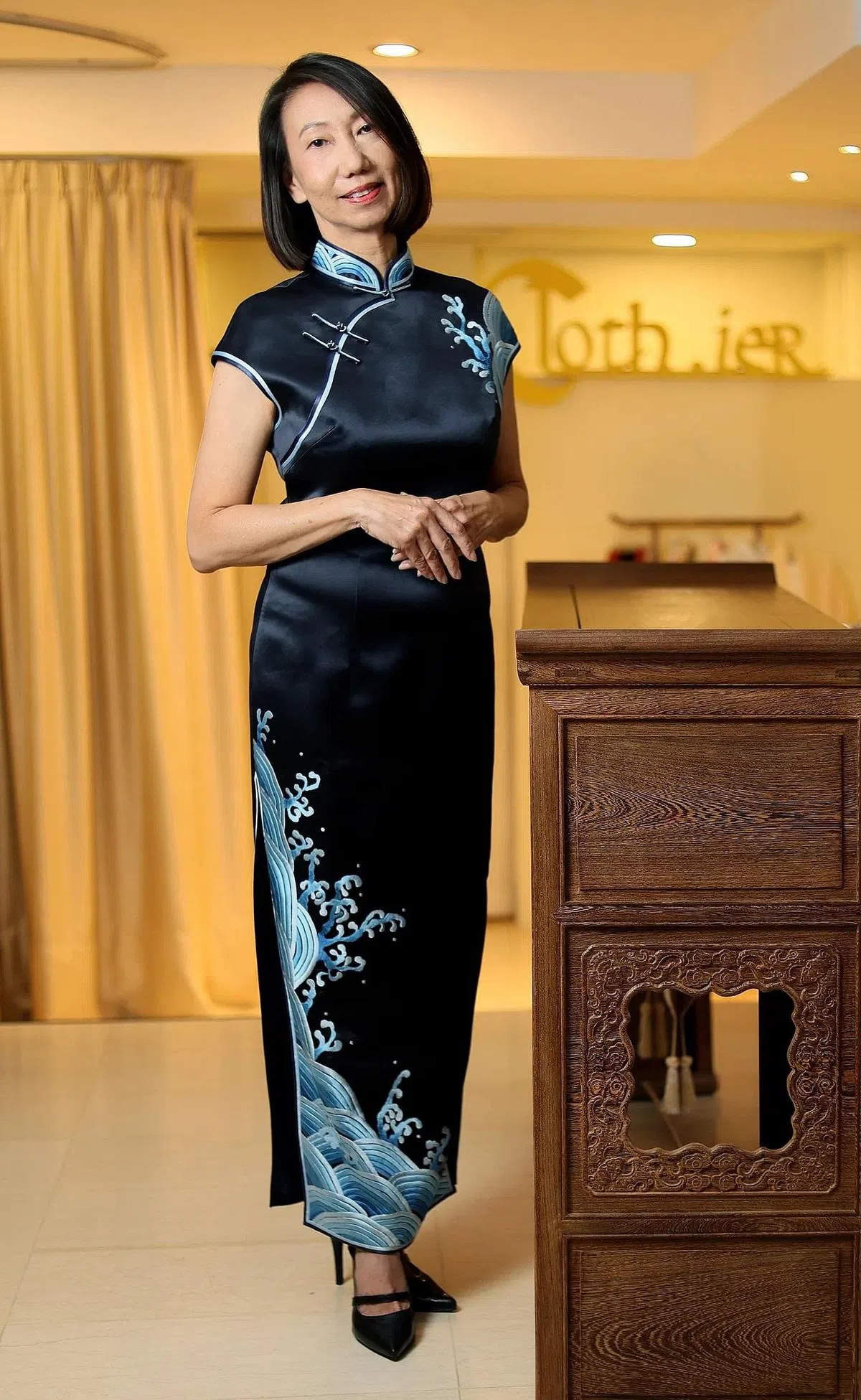 何萍萍坚持传统旗袍的温润美，身着绸缎做的长旗袍，领口和刺绣带出细节。（龙国雄摄）