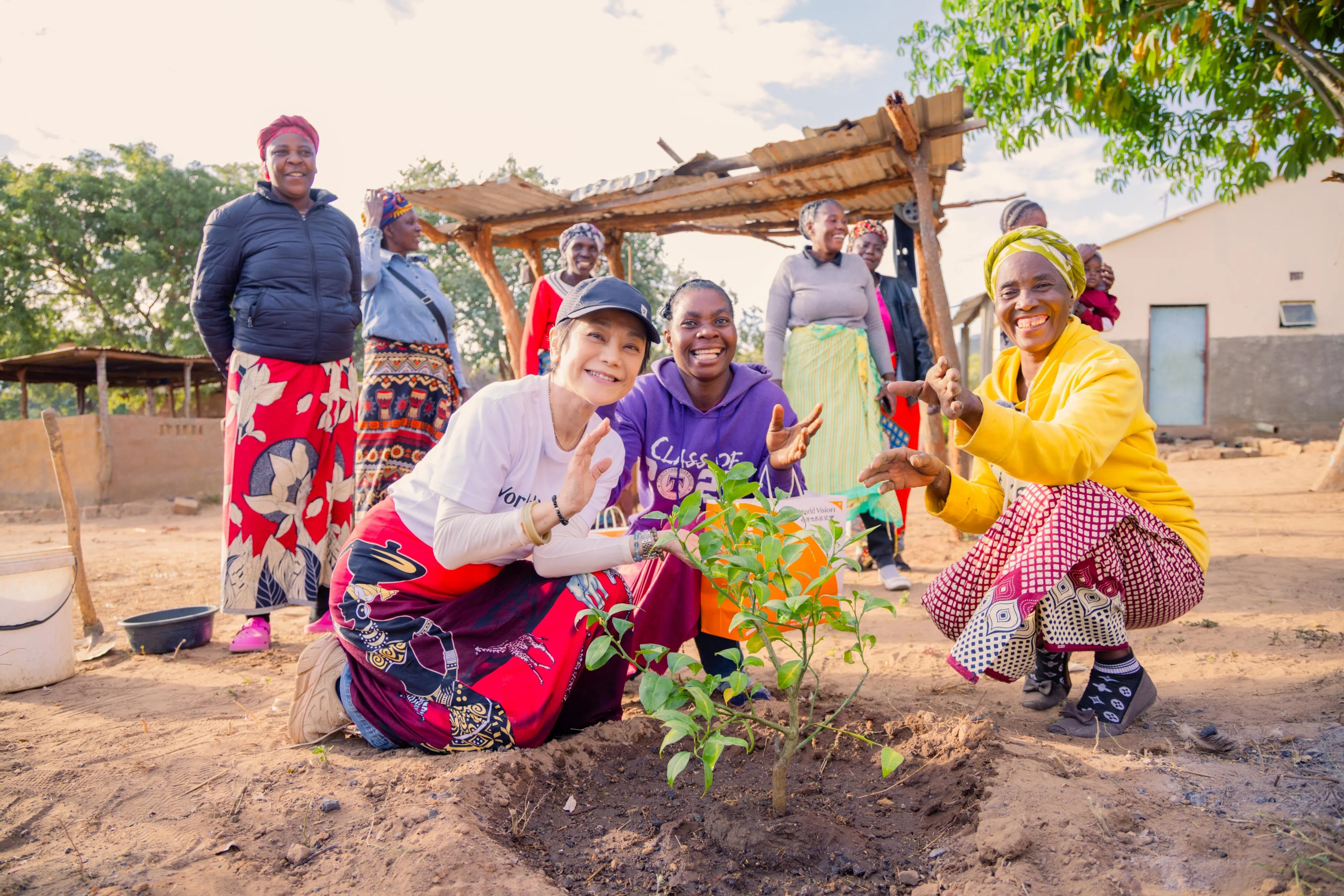 张艾嘉（前排左一）和妇女农民团体一起制作有机肥料，种下树苗，村民更将这棵树命名为“艾嘉树”。（世界宣明会提供）