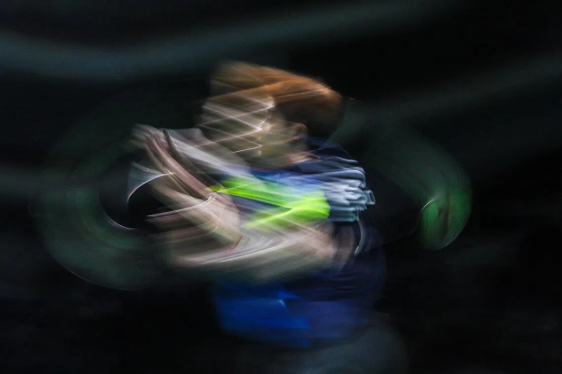 我国选手郑加恒在男子羽毛球团体赛中挥拍击球，全情投入。（白艳琳摄）