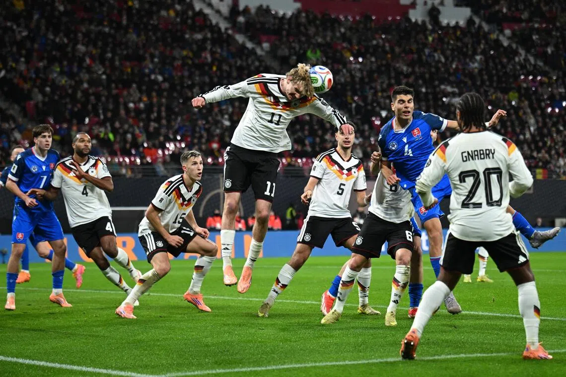 身高1米98的德国前锋沃尔特马德（中白衣）高高跃起，用一记头槌为主队首开纪录。（路透社）