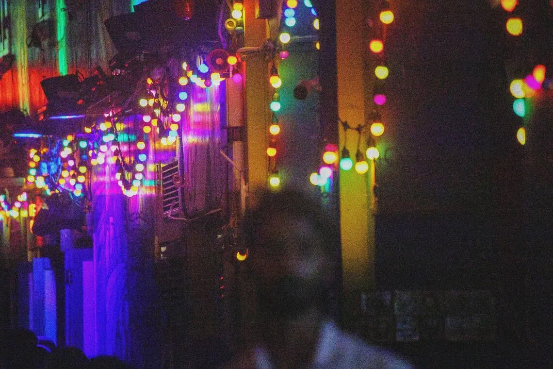 彩灯点亮夜色，流动的人影与朦胧光斑交织。（龙国雄摄）