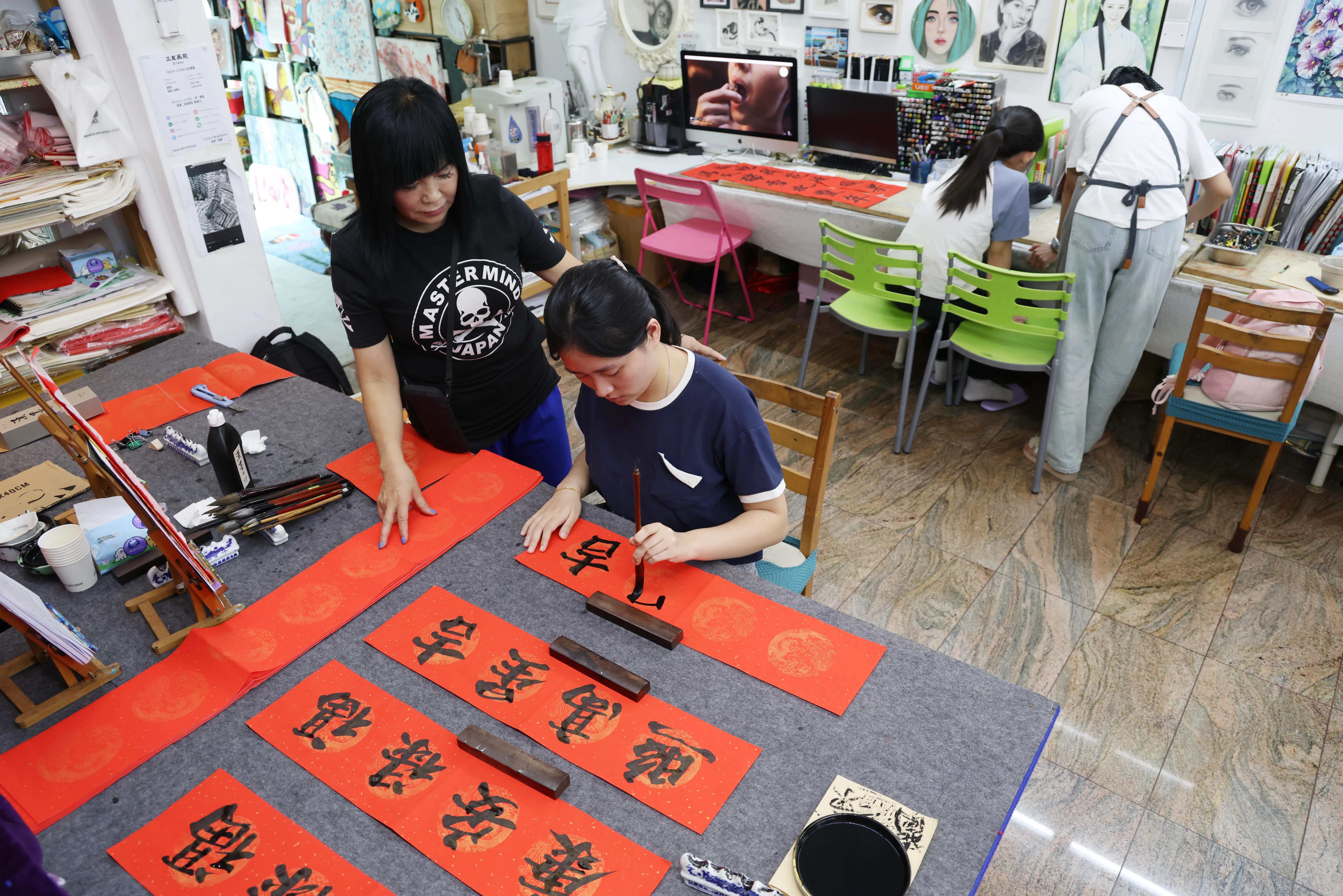 国大二年级学生林善熙（习字者），已学了两年书法，马年将至，她对学习画马也充满期待。（郑一鸣摄）
