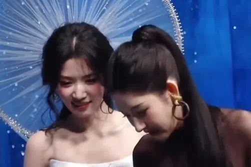 卢昱晓（左）的巨型头饰不小心打到王玉雯。（互联网）