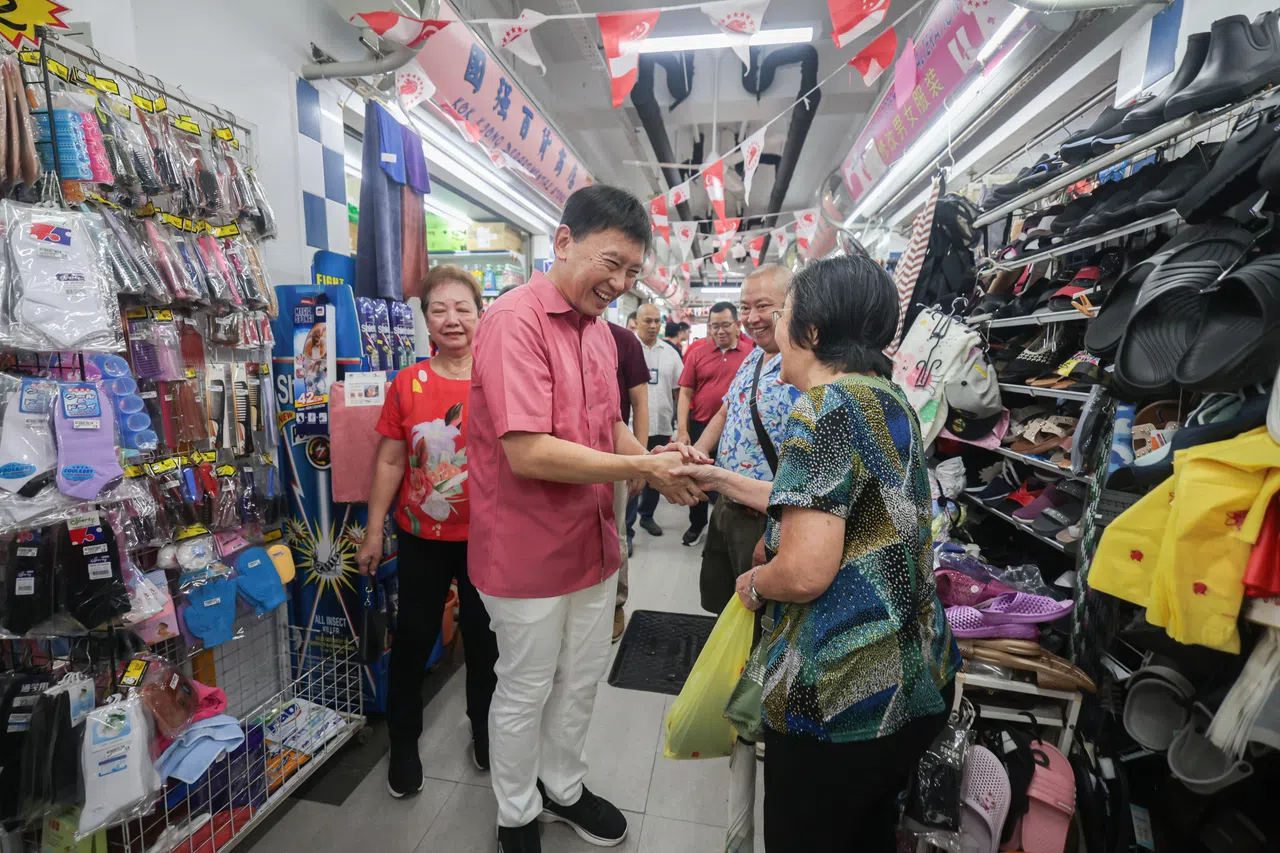 也是碧山—大巴窑集选区议员的国家发展部长徐芳达（左）主持剪彩仪式后，与摊贩和居民交谈。（李冠卫摄）