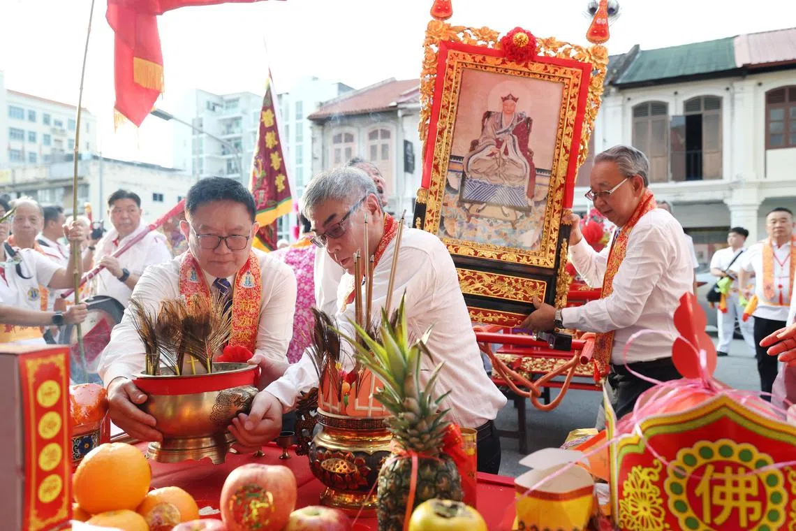 普救善堂总理林怡丰（左）、第一副总理黄伟忠（中）和司理庄永成（右）在林三成香纸庄取香。（郑一鸣摄）
