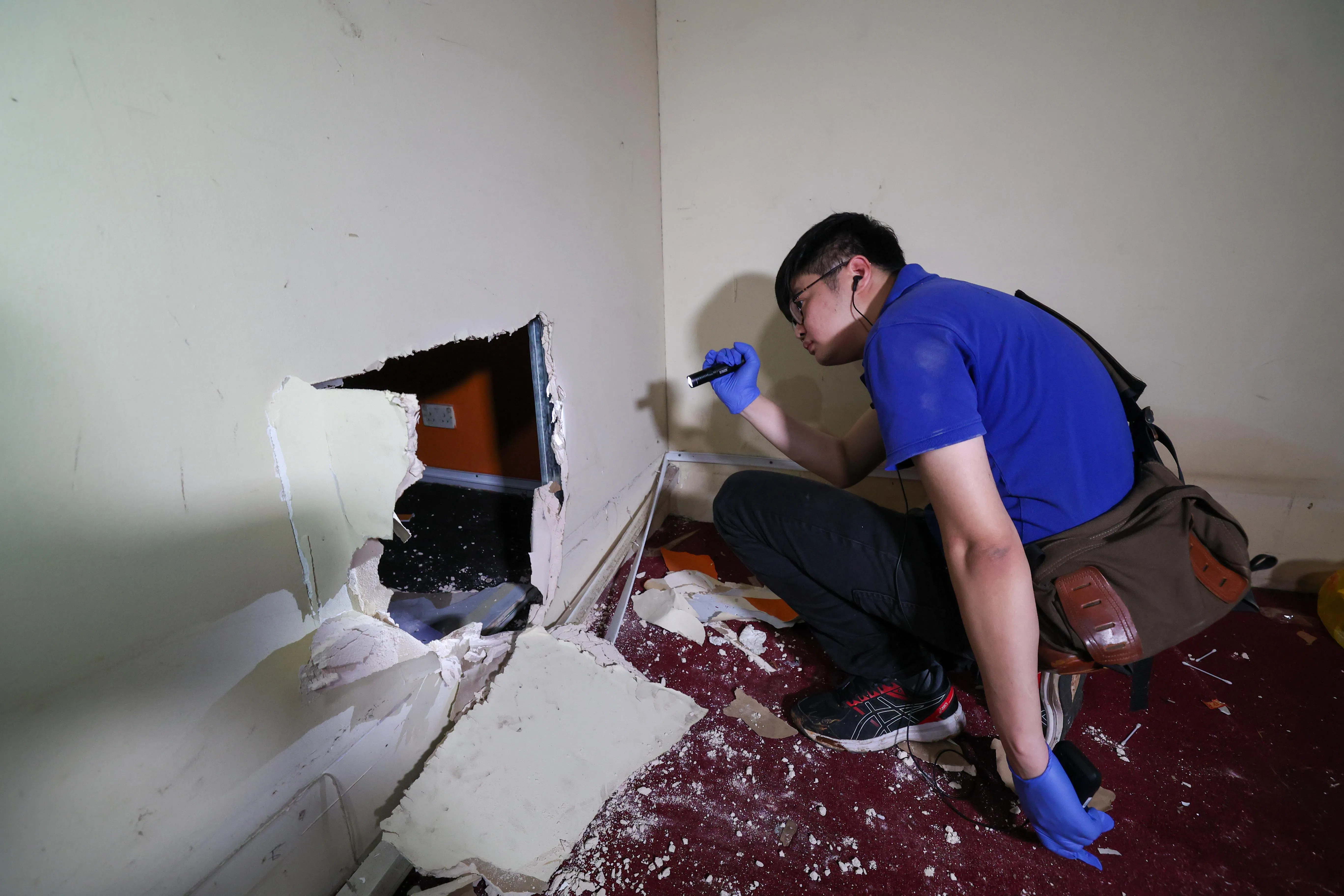 警方在空置的工厂墙壁上发现几处凿出的破洞，相信是为了能够及时逃走，躲避稽查人员。现场也有酒罐、纸巾，以及漏税香烟等物品。（陈斌勤摄）