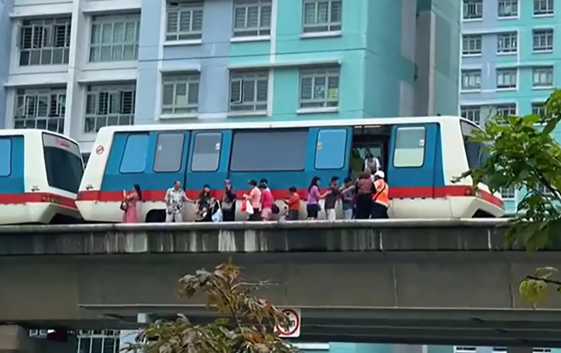 相信是在实加站附近，一列列车停在轨道上，一组乘客在工作人员协助下，一一下车，沿着轨道走回车站。（取自TikTok用户vincentkiapkiap）