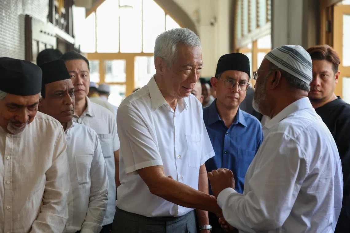 国务资政李显龙（中）与主管回教事务代部长费绍尔副教授（蓝衣）到赛依萨的治丧处吊唁。（数码发展及新闻部提供）