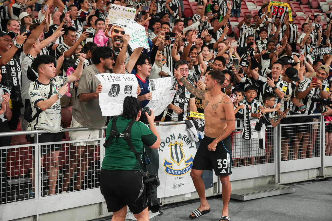 纽卡斯尔队长吉马良斯在赛后将球衣送给球迷，并和他们互动。（李冠卫摄）