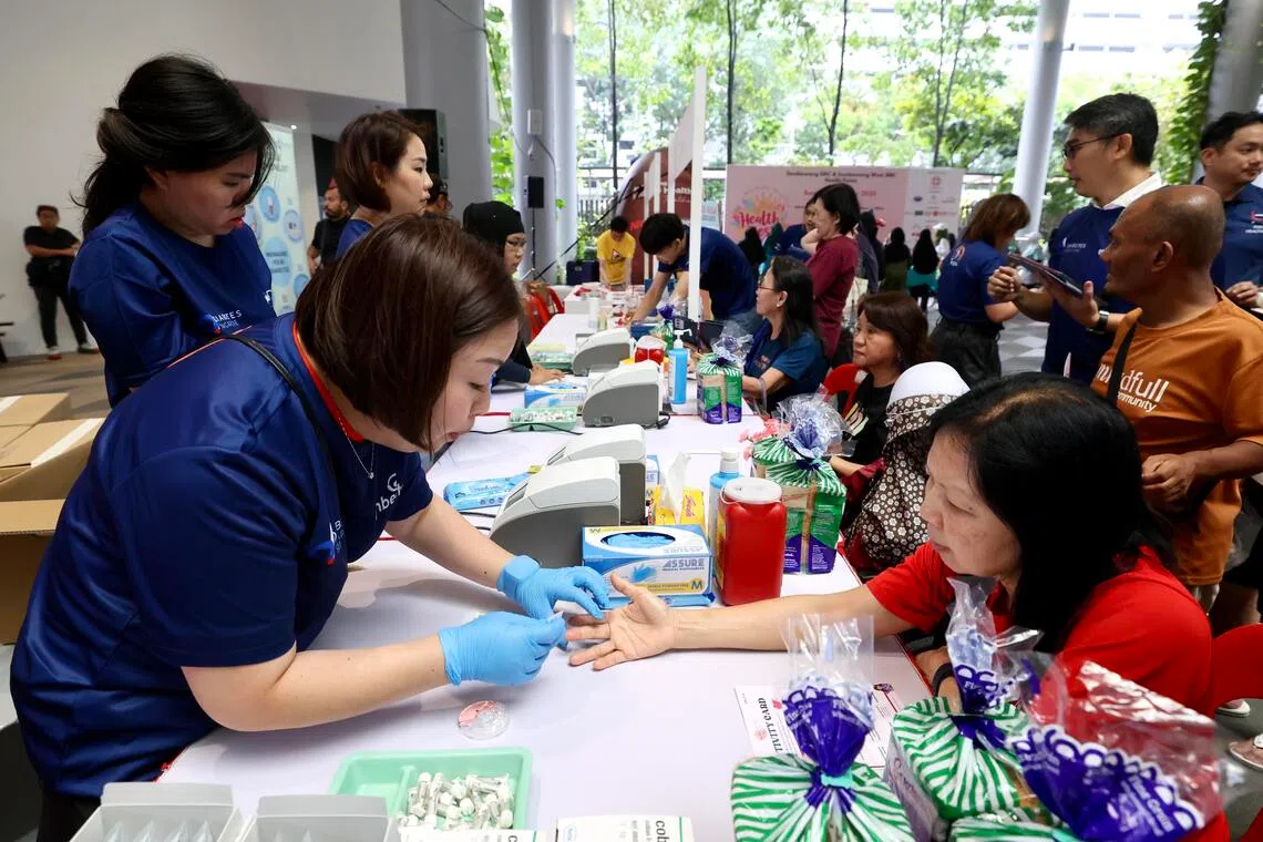 除了宣导保健信息，星期天的保健嘉年华活动也提供血糖筛查等服务，图为居民在新加坡糖尿协会的咨询站接受抽血和验血。（陈斌勤摄）
