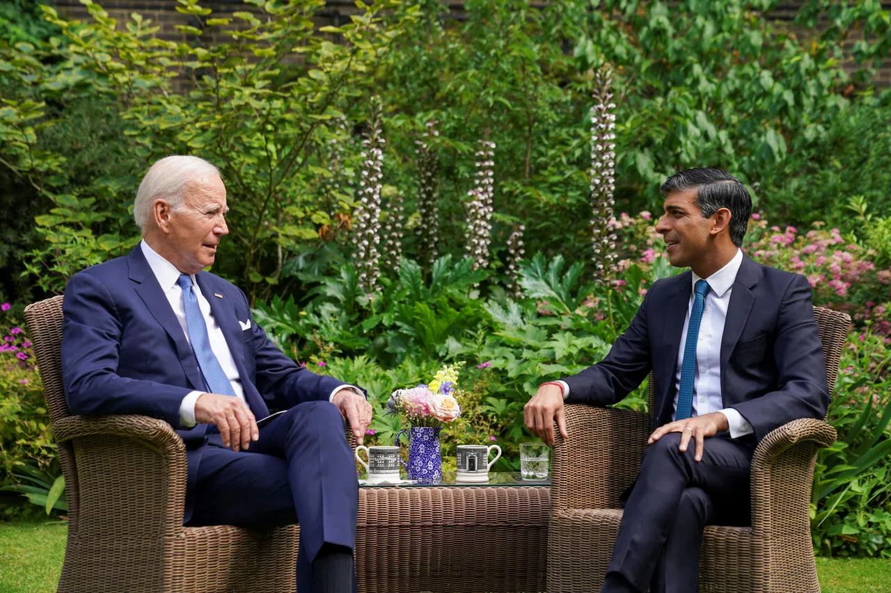 在会见查尔斯三世之前，拜登（左）与英国首相苏纳克（右）在后者的唐宁街办公室花园里交谈。（路透社）