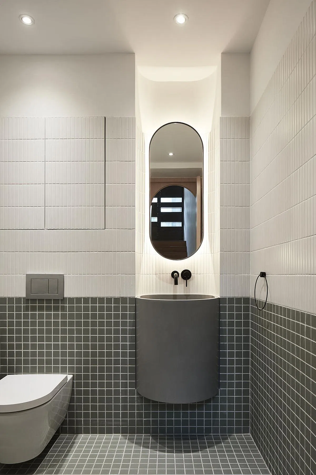 圆形洗手盆嵌入半圆壁龛，抬头是一面椭圆镜子，让人不得不佩服设计师将圆进行到底的巧思。