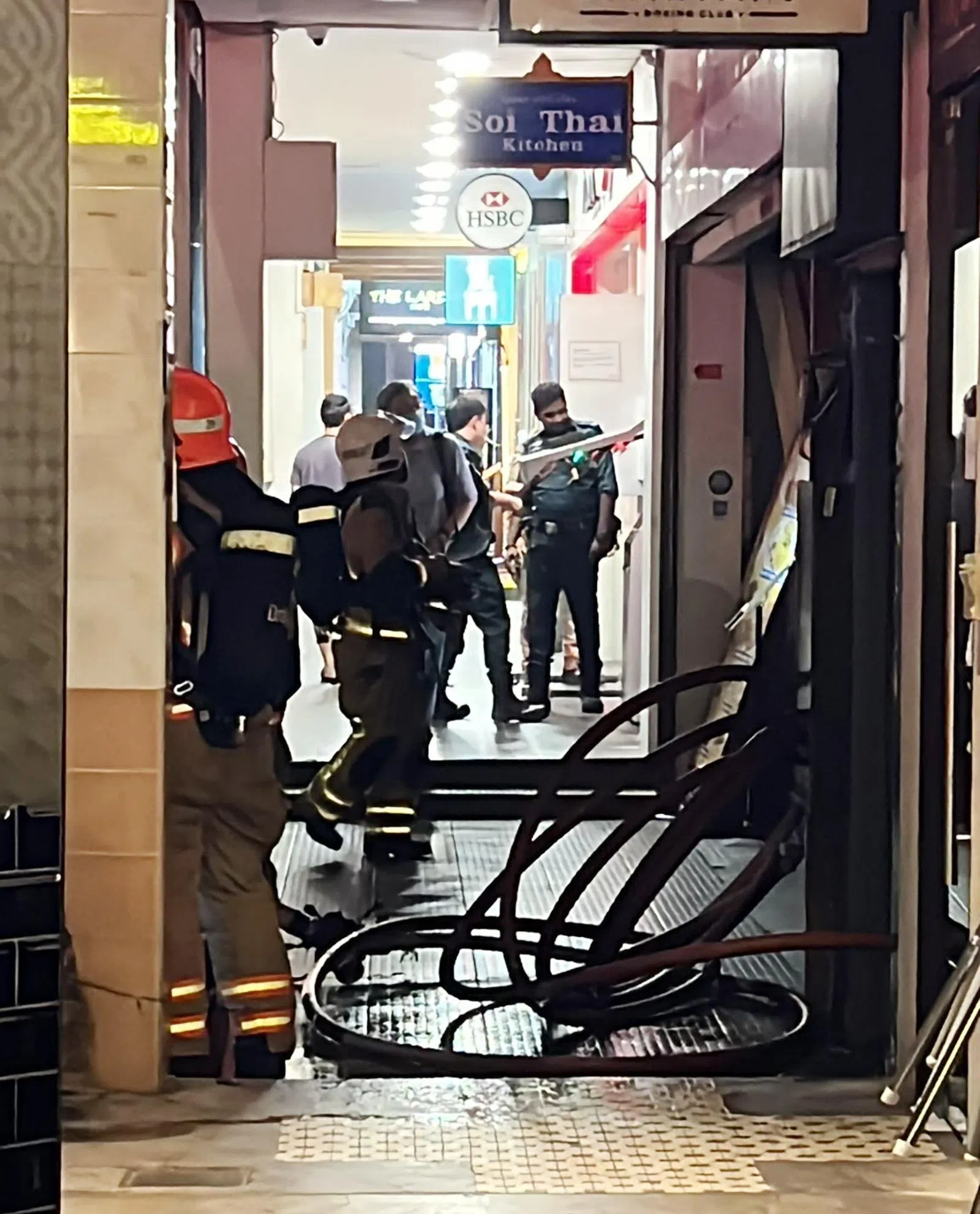 实龙岗花园一家在二楼的卡拉OK店失火，火势被扑灭后，民防人员准备撤离。（吴伟国摄）