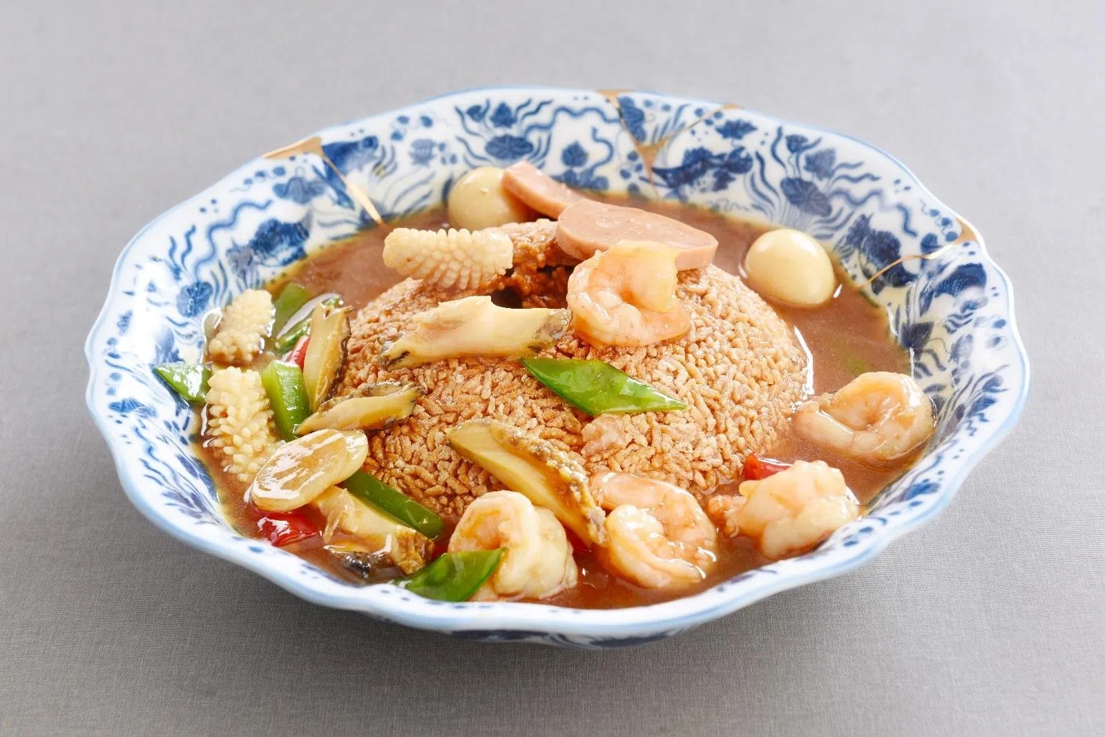 锅巴海三鲜以香脆锅巴搭配鲜嫩海味，服务员现场敲开锅巴，增添互动体验。　（餐馆提供）