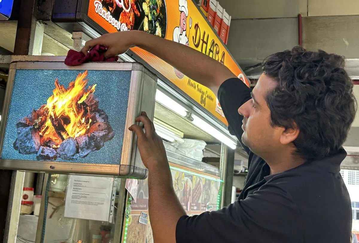 员工事后帮忙清理布满灰尘的招牌。（曾美玲摄）