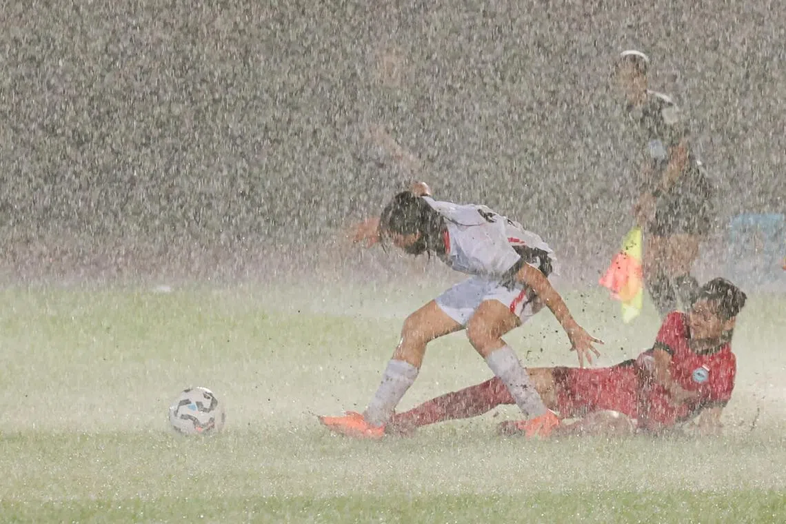 比赛后期雨势磅礴，双方拼抢时都很难站稳。（李冠卫摄）