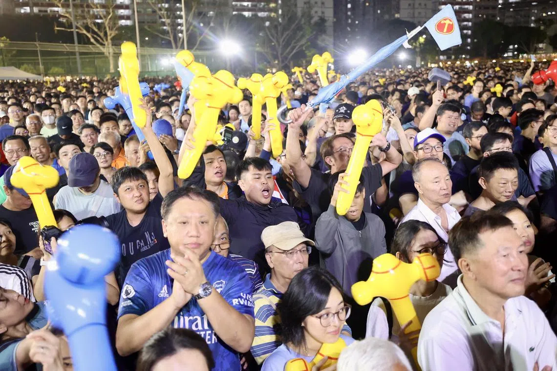 工人党群众大会现场人潮拥挤，主持人还得要求支持者往前移动，让更多人进入草场。住在周边组屋的居民也纷纷站在走廊聆听和观看群众大会。（邝启聪摄）