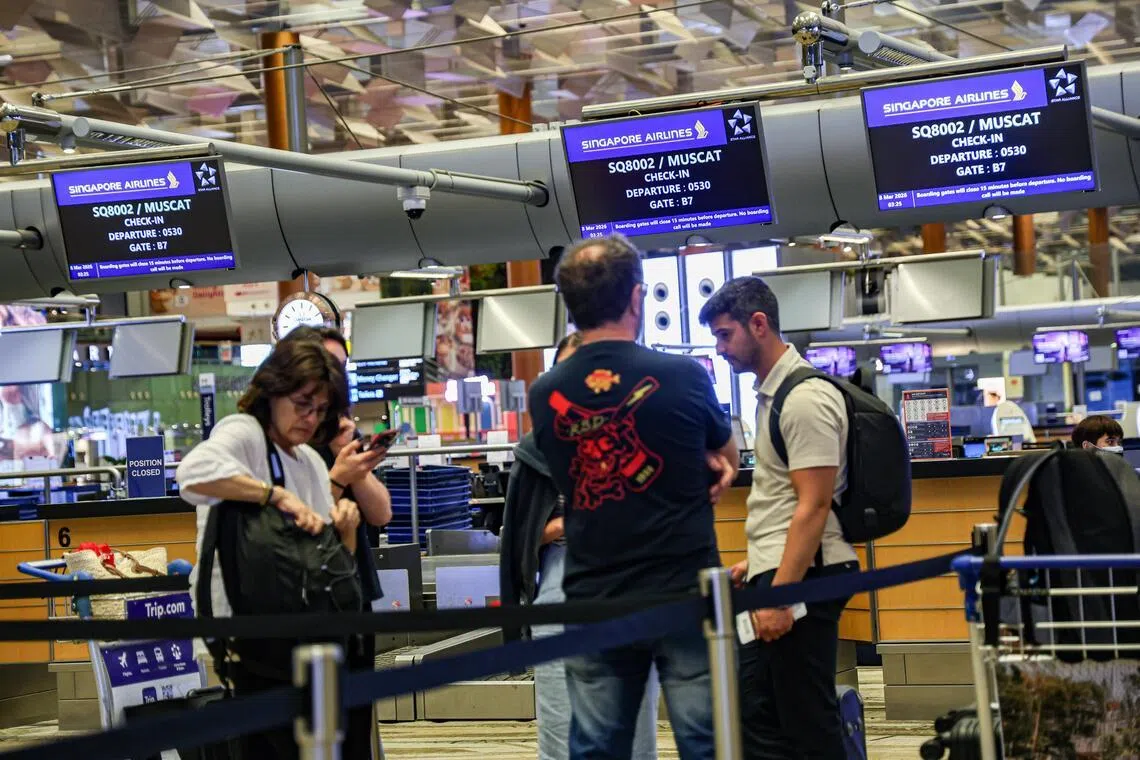 部分旅客因未持有进入阿曼所需的旅行证件，或没有续航的机票而无法顺利登机。不少人在现场尝试搜寻续航的机票。（关俊威摄）