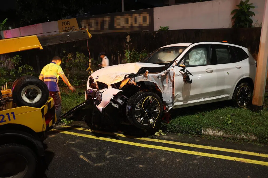 白色宝马汽车车头损毁严重，车内安全气囊弹出，整辆车从车祸发生地点打转冲入约50米外的草坪。（新明日报）