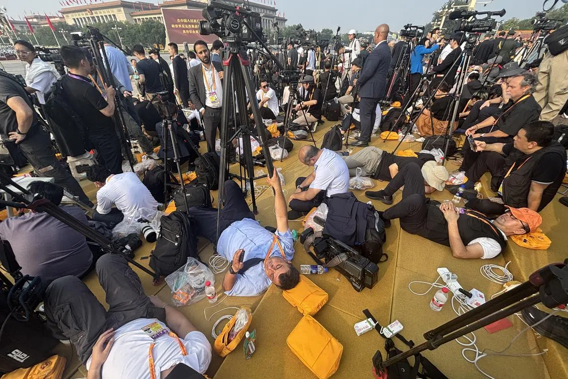 一些记者趁阅兵式开始前，躺在媒体拍摄区补眠。（林展霆摄）