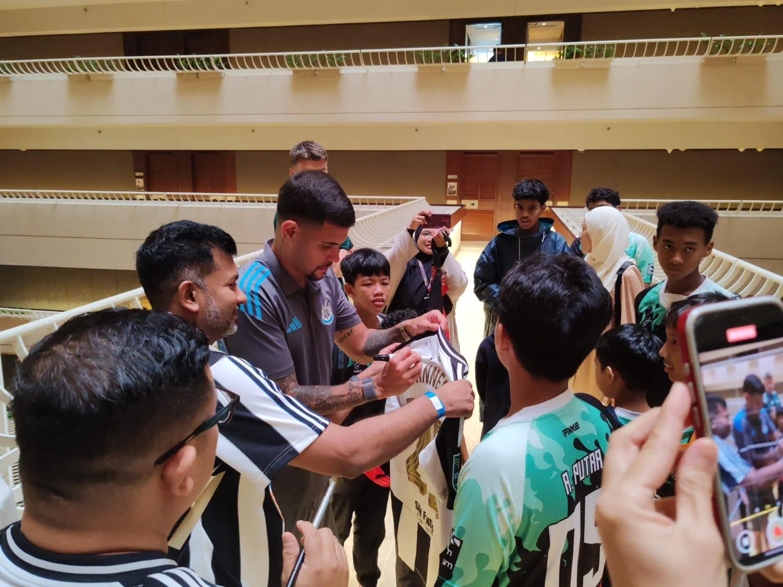 吉马良斯（左三）在记者会结束后为球迷签名。（陈明耀摄）