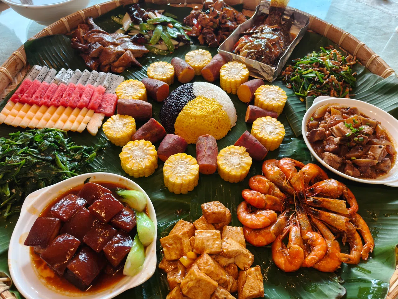 当地招牌美食簸箕饭，用芭蕉叶摆盘，各色美味秀色可餐。（李雅歌摄）