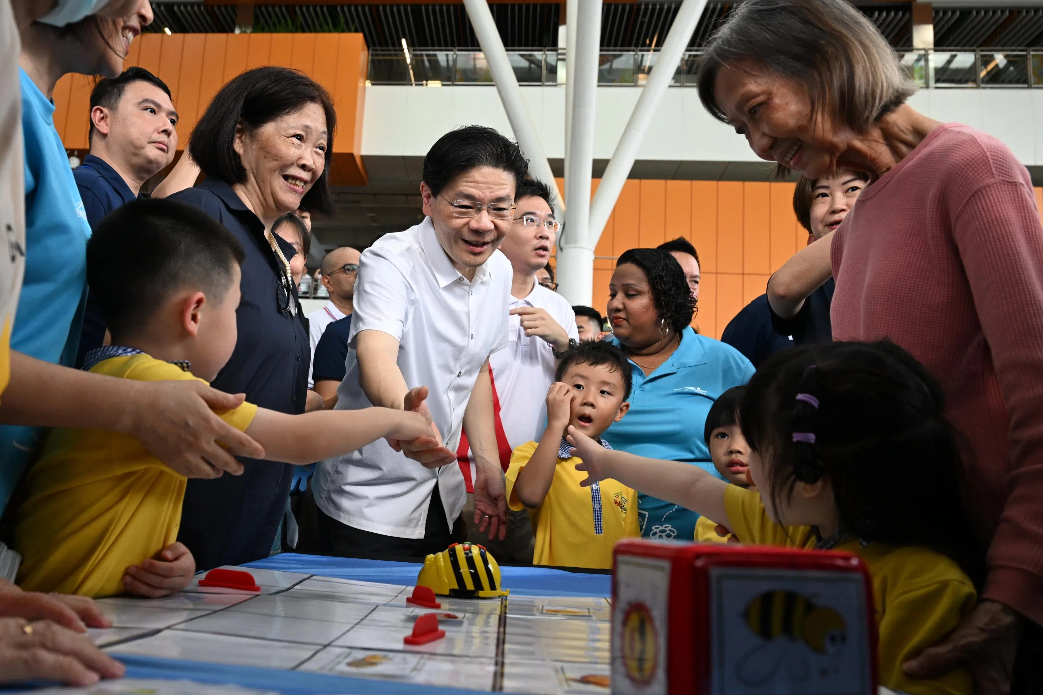 黄总理（白衣）在榜鹅综合社区中心One Punggol开幕式上与居民握手。（海峡时报）