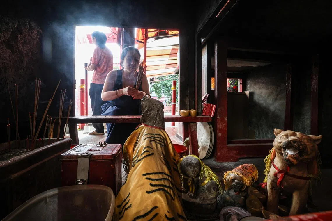 虎爷坛在神庙主殿外的香坛下。记者抵达时，有不少信众正在给其他虎爷像上香。（关俊威摄）