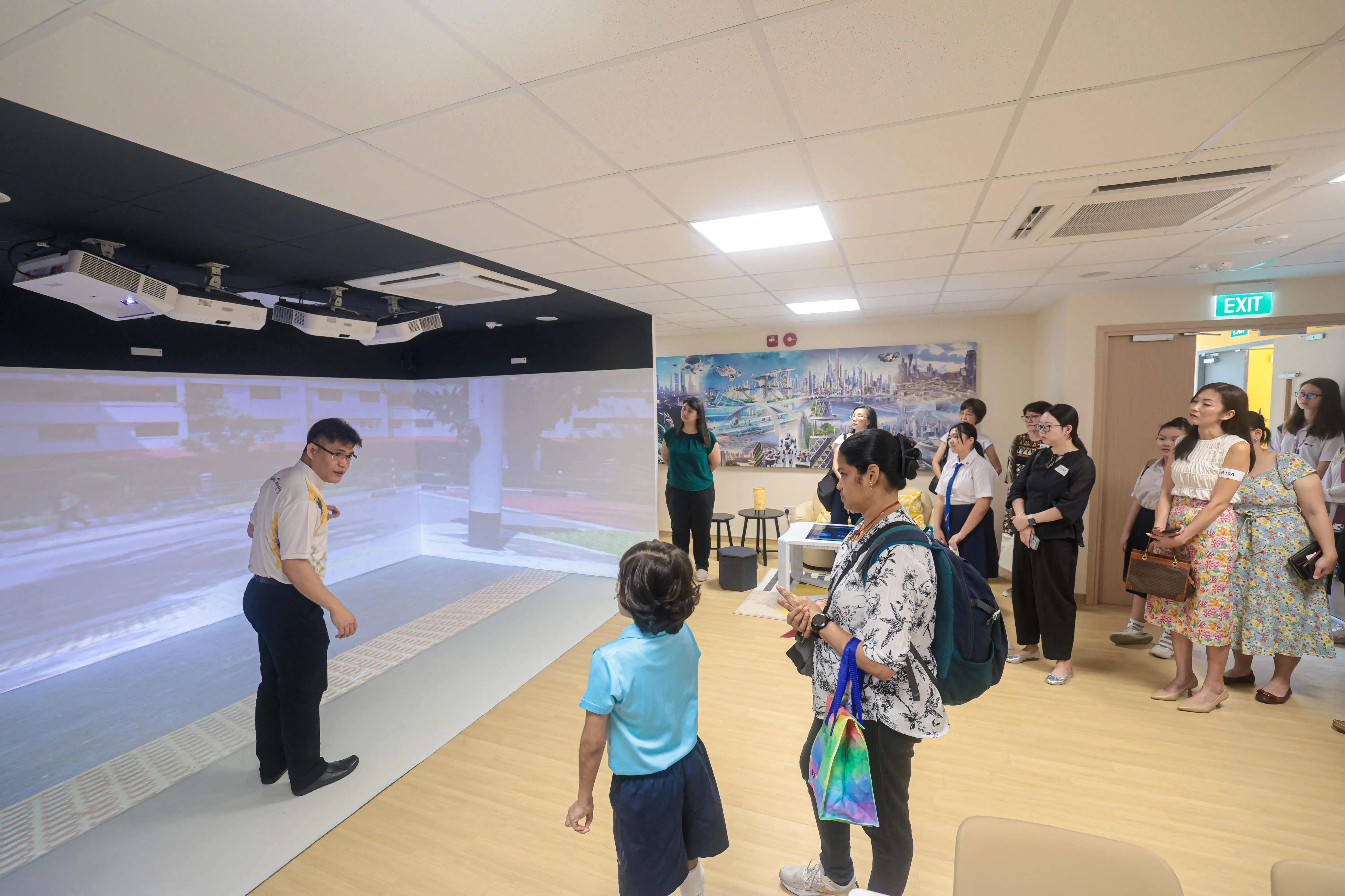 朝阳学校老师在创新中心（Innovation Hub）向访客介绍社区出行训练软件。软件设有虚拟实境（VR）功能，可模拟学生从学校出发的出行路线，途中显示学校门口的红绿灯，教导学生如何安全过马路。（李冠卫摄）