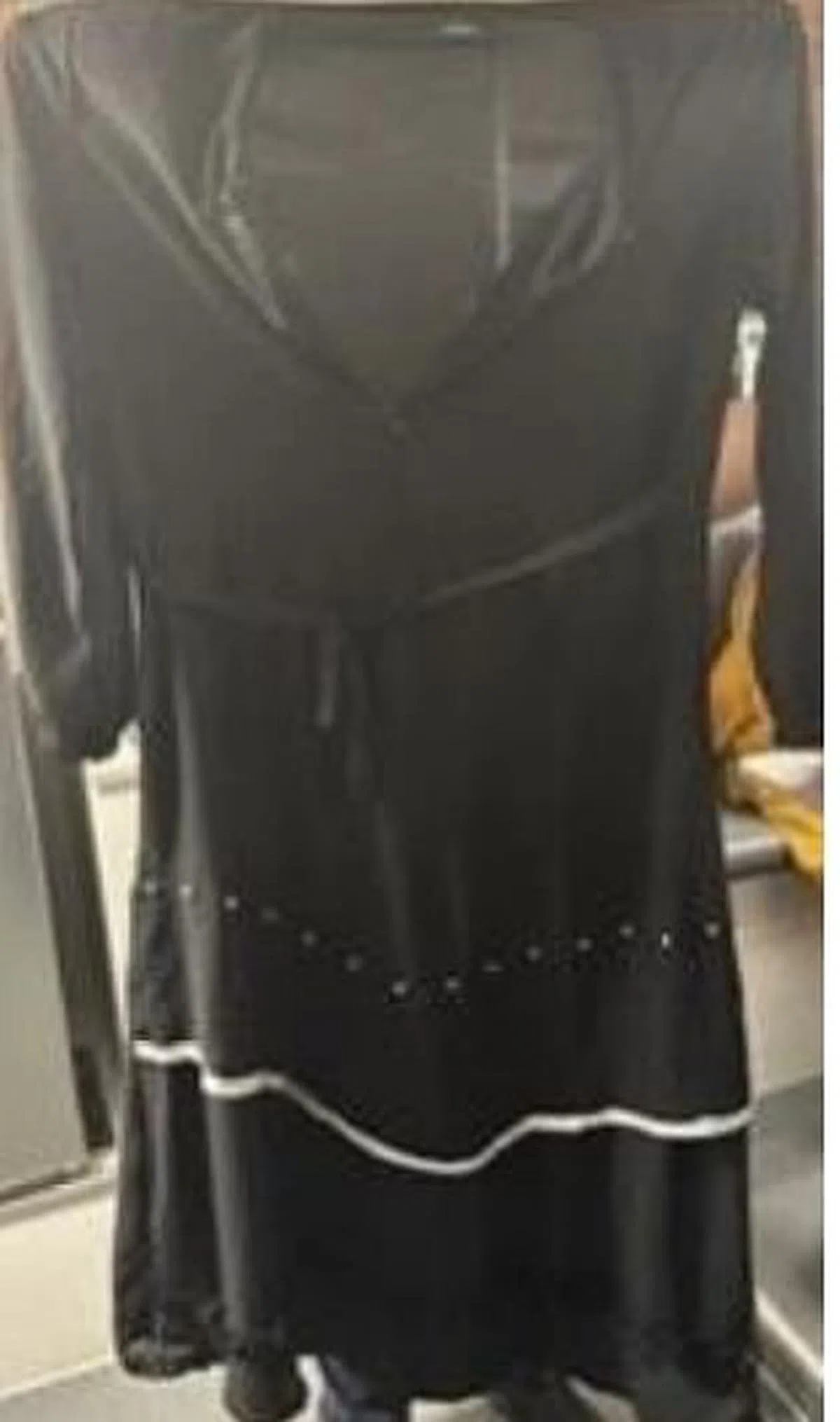 调查显示，女子与受害者相识，为隐藏身份，她特意换上一条黑色长裙并戴上口罩。（警方提供）