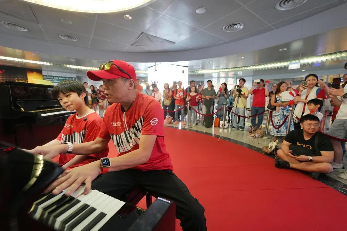 本地最年轻的街头表演者之一许晟宇（左）和音乐人陈·罗伯特·卫斯理（右）星期六为SMRT的24小时钢琴演奏马拉松献艺，两人四手联弹把现场气氛推向高潮。（谢智扬摄）