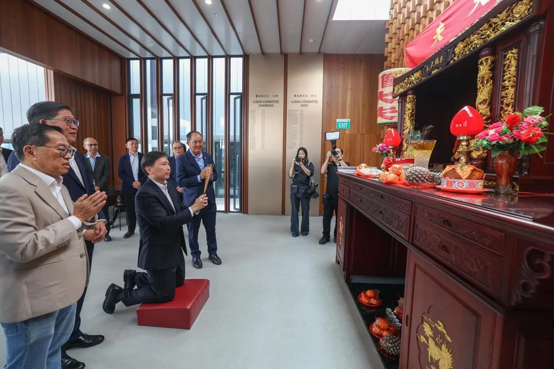 新加坡建筑商公会建设中心设有明德堂供奉建筑祖师鲁班大师。国家发展部长徐芳达（中）星期五到访时上香致敬。（白艳琳摄）