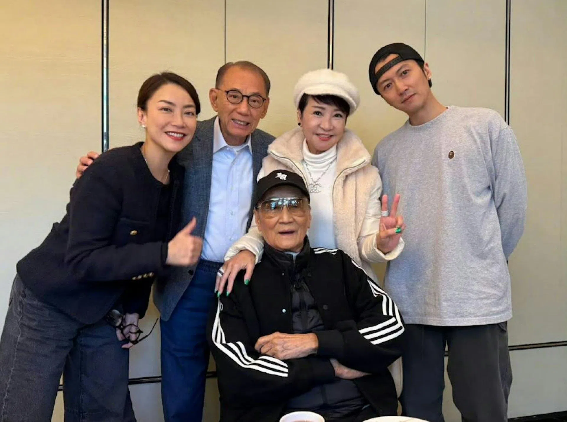 谢霆锋（右一）、狄波拉（右二）和四哥谢贤（坐着者）一家三口合照罕见曝光。左一、左二为英皇经纪人霍汶希和老板杨受成。（互联网）
