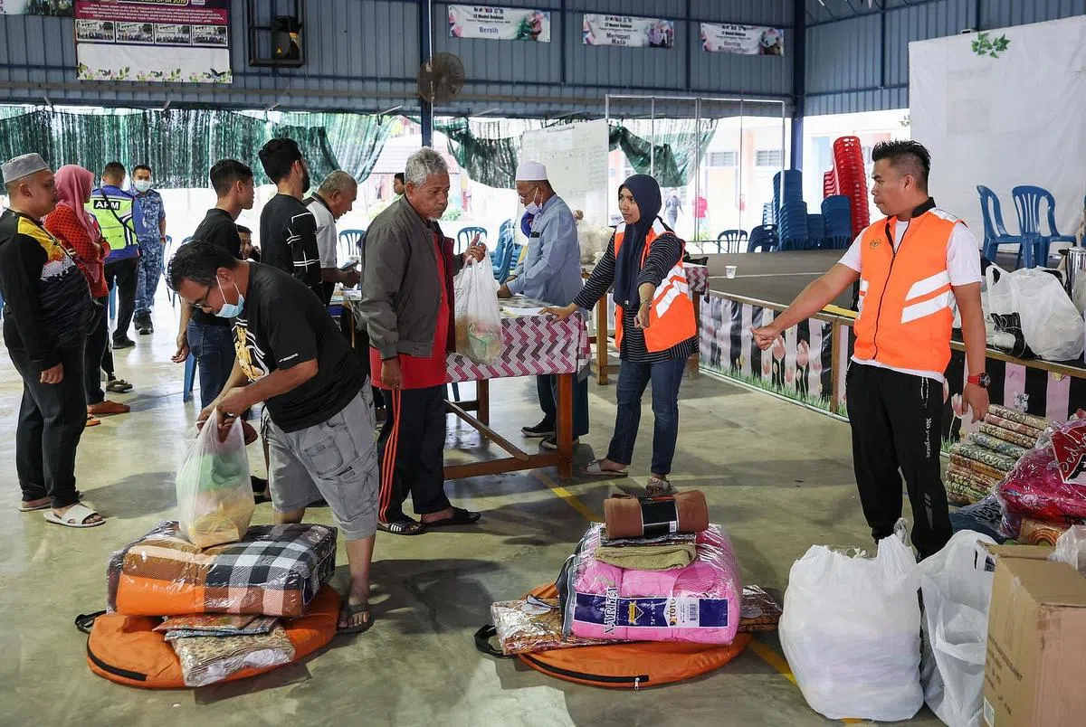 瓜拉登嘉楼灾民前往疏散中心登记并领取救济物资。（马新社）