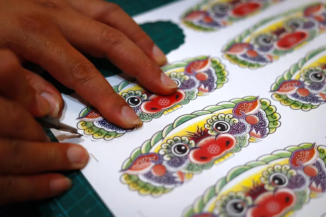 对设计有要求，所需的量又少，陈贵财只能自己设计、打印和切割。这个狮头图案可用在纸扎神像肩上的盔甲和腰带扣子。（龙国雄摄）