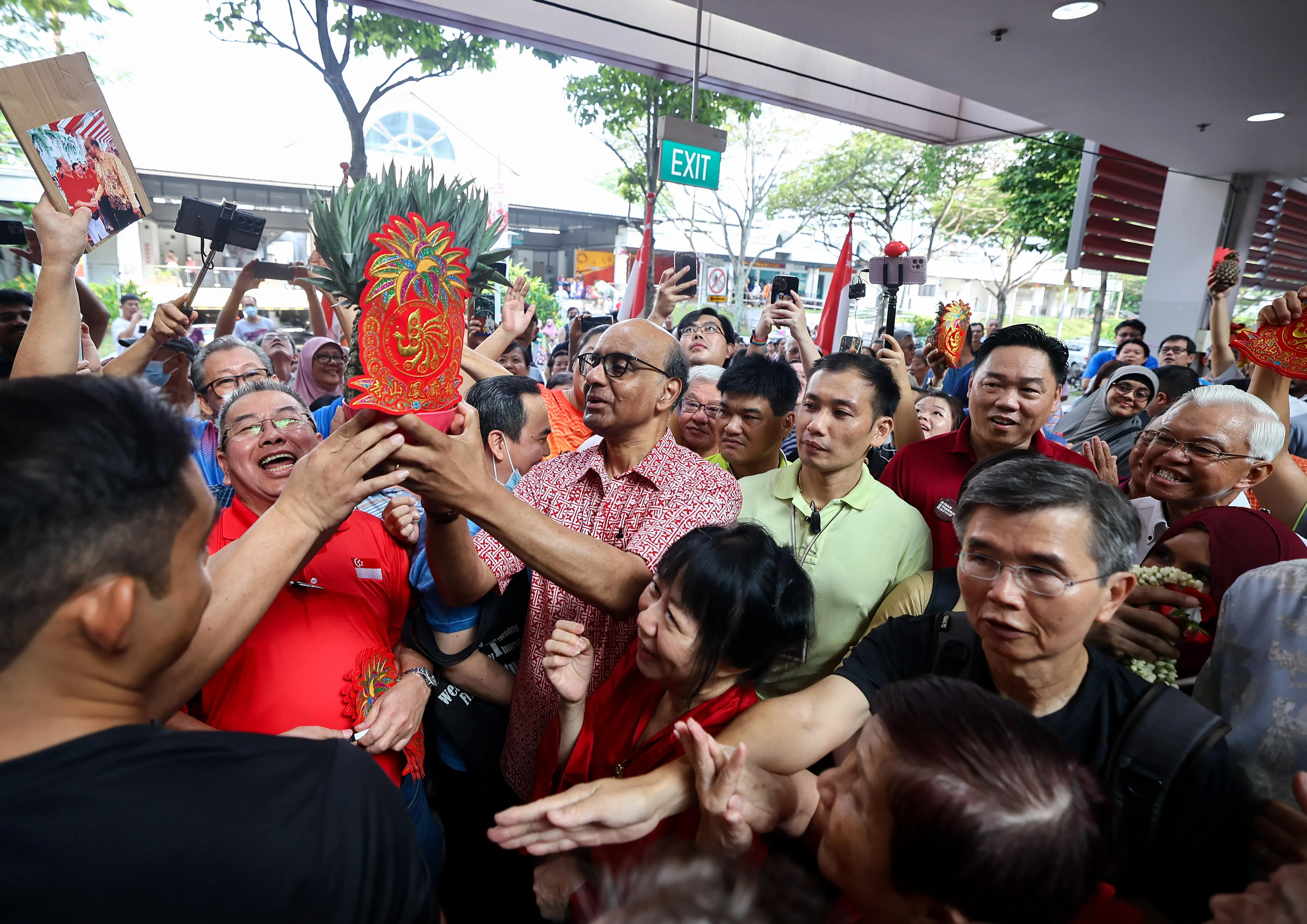 尚达曼（中）与支持他的民众一同手举黄梨，一起用福建话喊：“旺来！发啦！”（陈渊庄摄）