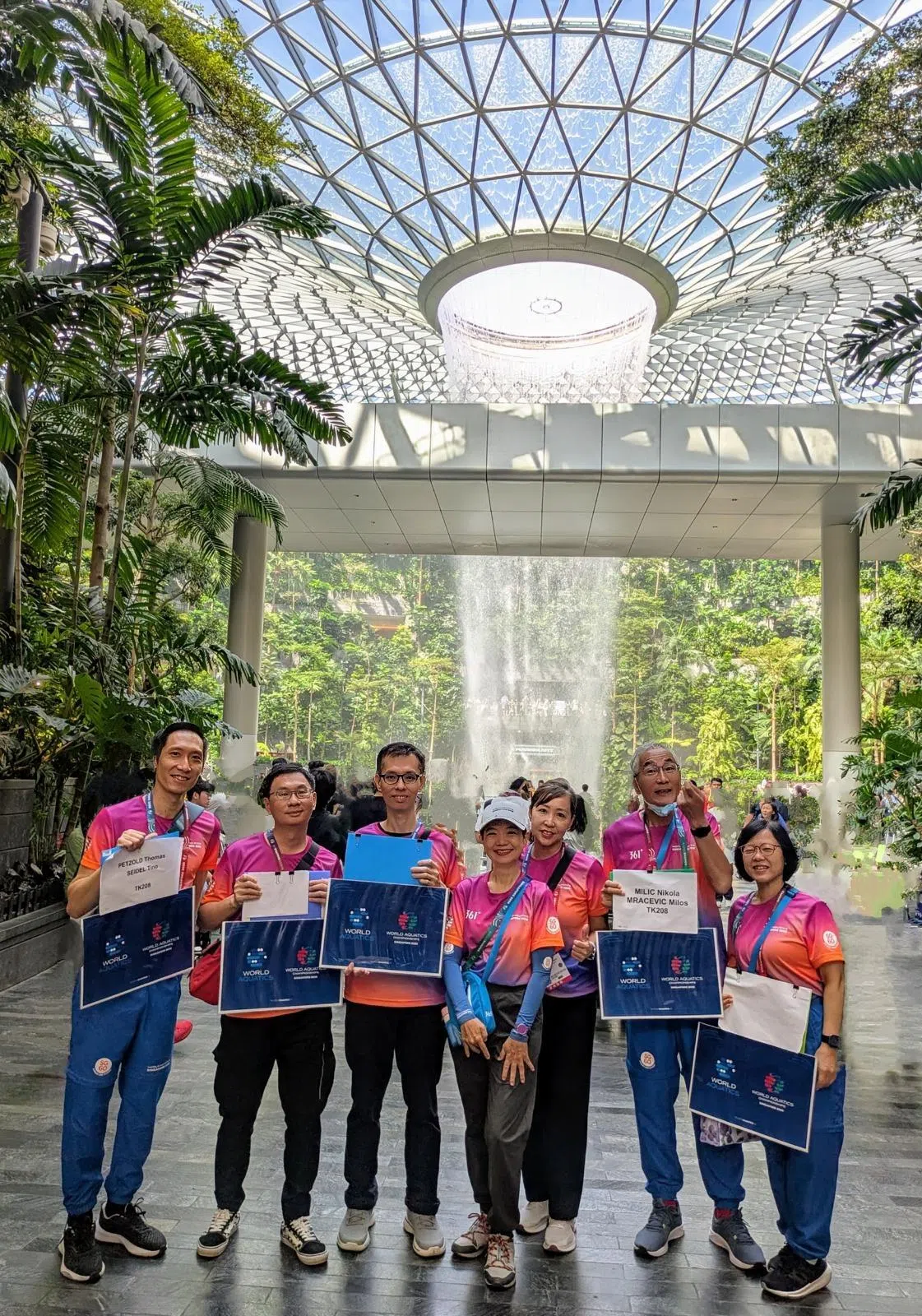 水上运动世锦赛期间，刘宗生（右二）、张立明（右一）夫妇作为尼拉团队志愿者，驻扎在樟宜机场，为飞抵狮城的国外运动员接风，并送他们上车。（尼拉团队提供）